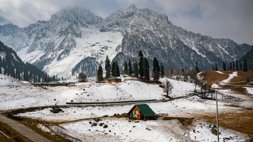 Snow-covered mountains and cabins in picturesque Sonamarg, a winter wonderland.